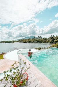 圣斐利-银港Peninsula Esmeralda Luxury Villas的水体旁游泳池里的男人