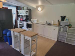 KaihuKai Iwi Lakes Resort的厨房配有白色橱柜和白色家电