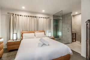 萨福克公园A Perfect Stay - Brandon St Beach and Spa的卧室配有一张白色大床和淋浴