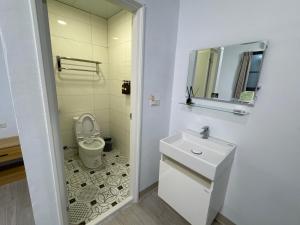 茄萣路科民宿的一间带卫生间、水槽和镜子的浴室