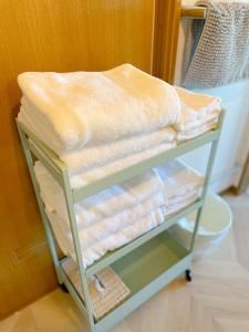 伊豆Izu Serenity Fuji-View Retreat with Private Onsen的一堆毛巾放在一个房间里架子上
