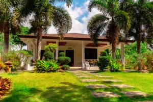 AmadeoPATIO BUENDIA FARM RESORT AND EVENTS PLACE的棕榈树和走道的房子