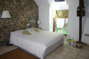 圣马洛圣克里斯多夫农场酒店的一间卧室设有一张床和石墙