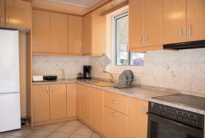 雅典Gtrip Ellinikon Experience Apartment - 31506的厨房配有木制橱柜和台面