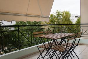雅典Gtrip Ellinikon Experience Apartment - 31506的阳台上的木桌和椅子
