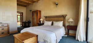 努尔德霍克Monkey Valley Resort的卧室配有一张白色大床和木制床头板
