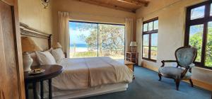 努尔德霍克Monkey Valley Resort的一间卧室配有一张床、一张桌子和一个窗户。