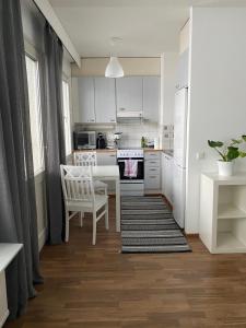 约恩苏Tilava yksiö Niinivaaralla的厨房配有白色橱柜和桌椅