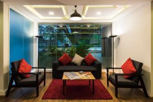 班加罗尔Townhouse MG Road,Bangalore的客厅配有沙发和两把椅子