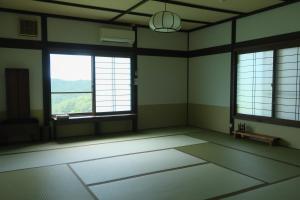 与谢野町Kaya Yamanoie的建筑中一间空房间,有两个大窗户