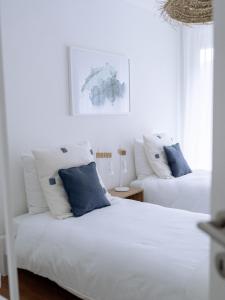 贝肯里德Chez-Marie Vue fantastique entre lac et montagne的一间卧室配有两张带蓝白色枕头的床