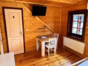 普列维扎Ubytovanie v Superior izbách v podkroví Koliba Pacho的小屋内的房间,配有桌子和电视