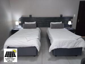 马里兰SnL 12 Dwergarend的配有2张床铺的酒店客房,提供白色床单和枕头