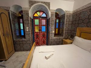 非斯Riad Fes Unique的一间卧室设有一张床和一扇红色的门