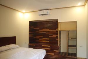 吉利特拉旺安Gili Tempoe的一间卧室设有一张床和木墙