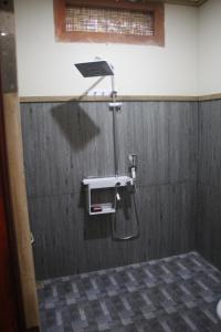 吉利特拉旺安Gili Tempoe的一间金属墙浴室内的淋浴