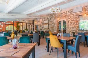 昂迪兹Logis Hôtel Restaurant Le Pradinas的餐厅设有木桌和椅子,拥有砖墙