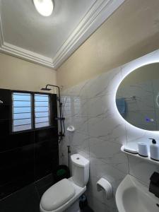 科托努MonGite的一间带卫生间、水槽和镜子的浴室