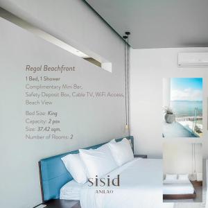 马比尼Sisid Anilao Resort的卧室配有一张挂有墙上标志的床