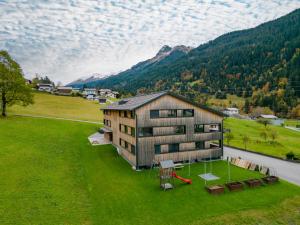 瓦尔德阿尔贝格Ferienwohnung "Urlaub am Arlberg"的享有带网球场的房屋的空中景致