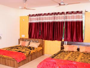 卡希德Vasantam Beach Resort的一间卧室设有两张床,窗户配有红色窗帘