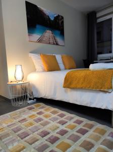 泰昂维Le LUX 31的一间卧室配有一张白色的床和橙色毯子
