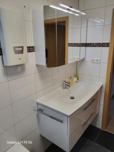 波鸿Apartment Bochum的白色的浴室设有水槽和镜子