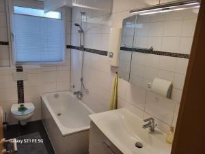 波鸿Apartment Bochum的一间带水槽、浴缸和卫生间的浴室