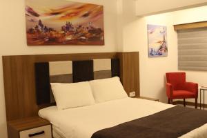 卡特佩RİVADA HOTEL的一间卧室配有一张床和一张红色椅子