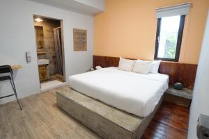 南湾山森三室墾丁包棟民宿3Rooms的卧室设有一张白色大床和一扇窗户。