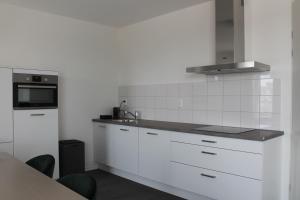 埃因霍温Trompstraat Eindhoven的白色的厨房配有水槽和微波炉
