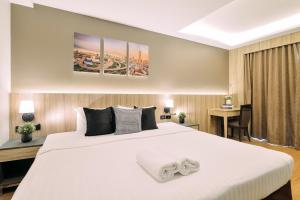 曼谷Tori crown hotel的卧室配有一张白色大床和一张书桌