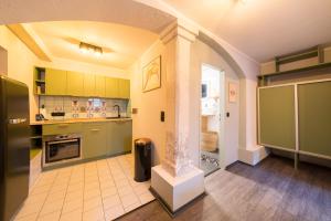 波茨坦Design Apartments - "Remise Blumberg"的一间设有绿色橱柜和柱子的大厨房