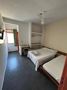 康塞桑达巴拉Pousada Itaúnas的一间卧室配有两张床和吊扇
