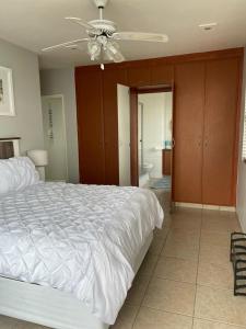 马盖特Dawn's Apartment的卧室配有白色的床和吊扇