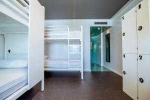 圣安东尼奥AMISTAT Island Hostel Ibiza - ALBERGUE JUVENIL的一间设有白色双层床和走廊的客房