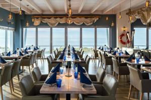 瓦尔内明德马克格拉芬黑德斯特朗度假酒店的一间配备有桌椅的海景餐厅