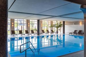 瓦尔内明德马克格拉芬黑德斯特朗度假酒店的一座配有桌椅的酒店游泳池