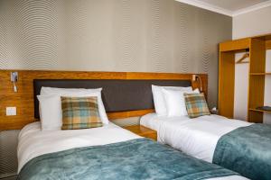 史云顿戈达德阿姆斯酒店的两张睡床彼此相邻,位于一个房间里