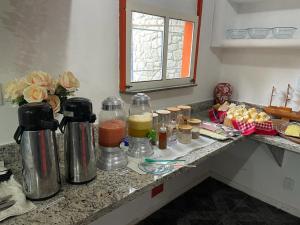康塞桑达巴拉Pousada Itaúnas的厨房柜台,提供瓶装果汁和其他食材