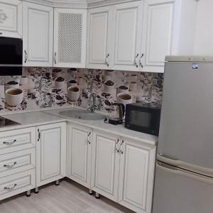 阿拉木图ЖК Молодежный的厨房配有白色橱柜和白色冰箱。