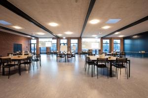 瓦尔德Sportium Sportel的用餐室设有桌椅和窗户。