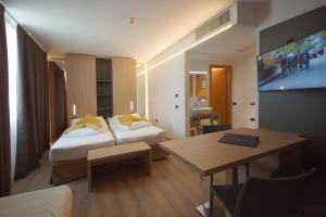 加尔达湖滨大使套房酒店的酒店客房设有两张床和一张桌子。