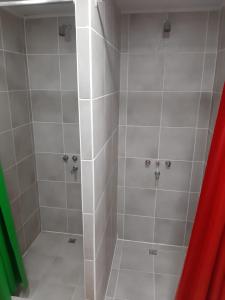 乌斯怀亚克鲁兹德尔苏尔旅馆的浴室设有白色瓷砖和淋浴。