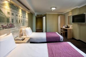 伦敦President Hotel的酒店客房设有两张床和一台平面电视。