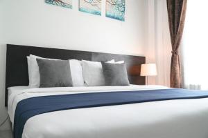 乌汶普莱梅维利知酒店的一间卧室配有一张带蓝色毯子的大床