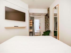 卢森堡卢森堡中心火车站宜必思尚品酒店的卧室配有白色床和平面电视
