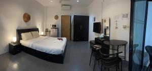 拉威海滩Lotus Bleu Resort & Restaurant的卧室配有一张床和一张桌子及椅子