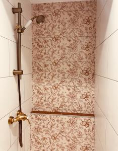 莫斯LA CABANE AFFRANCHIE的带淋浴的浴室,配有花卉壁纸