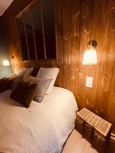 莫斯LA CABANE AFFRANCHIE的卧室配有木墙内的一张床